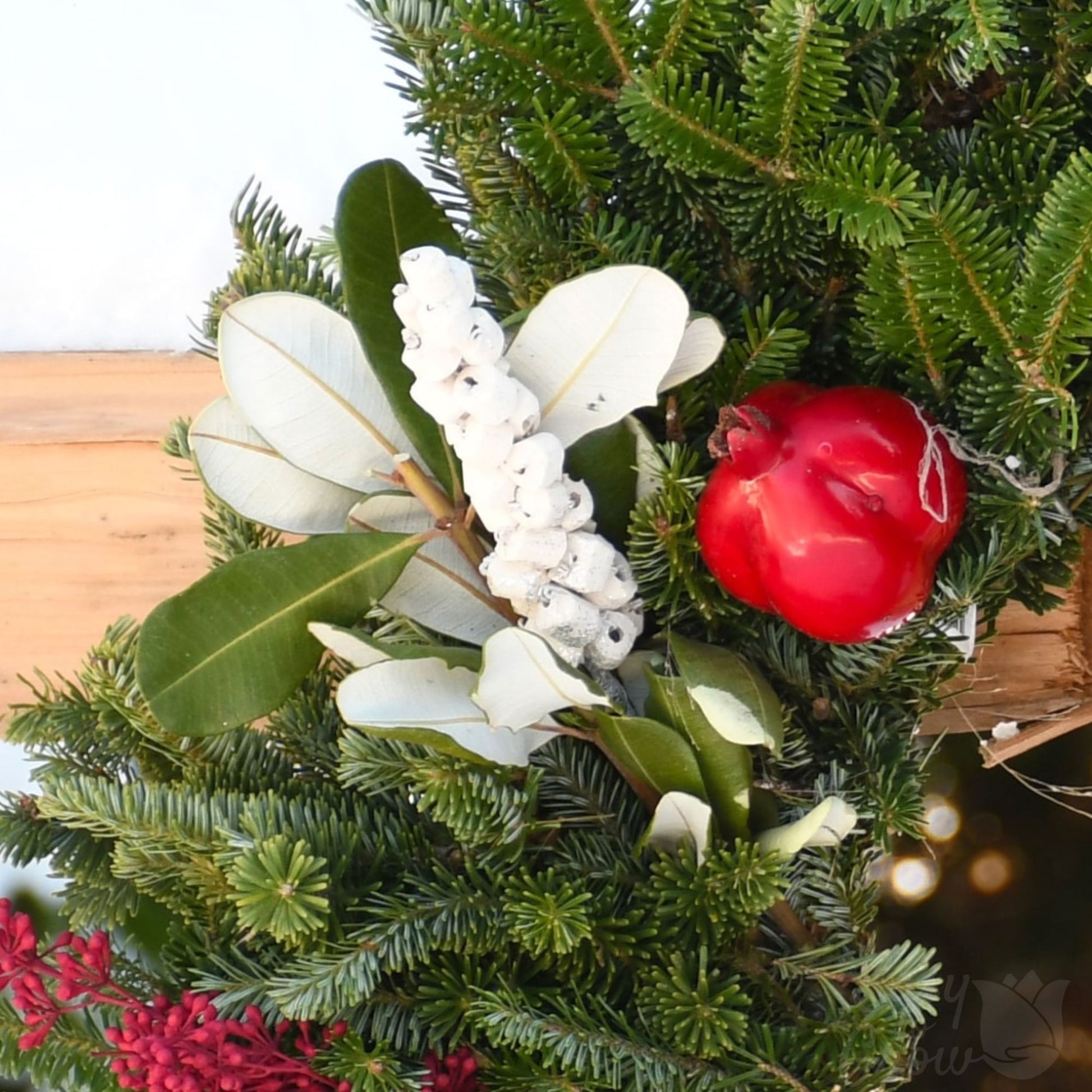 Winter Orchard luxe wreath zoomed in on green pine or fir, and white foliage and red accents.